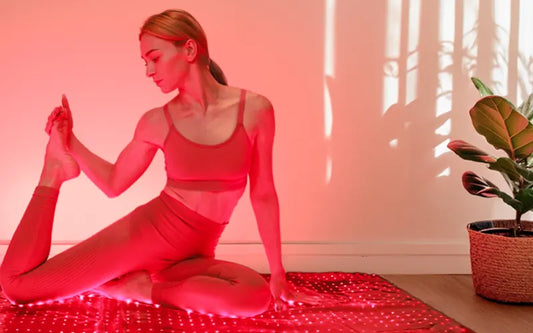 Woman sitting on a red light therapy mat