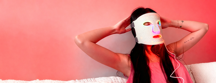 Person wearing a colorful LED face mask with white background