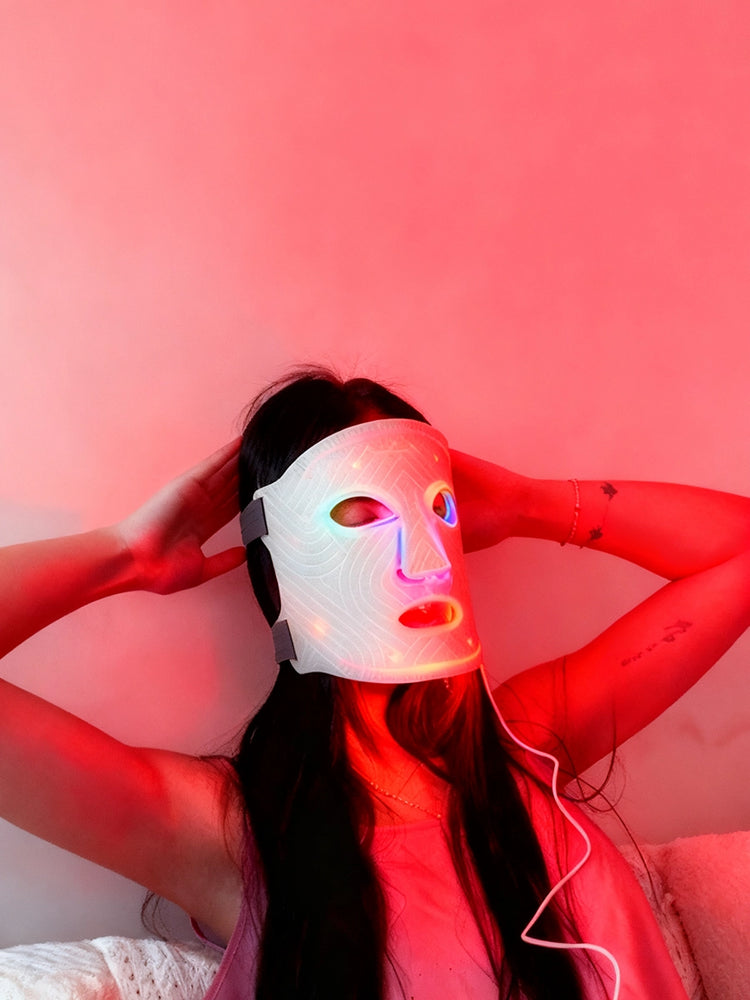 Person wearing a LED face mask with a white background