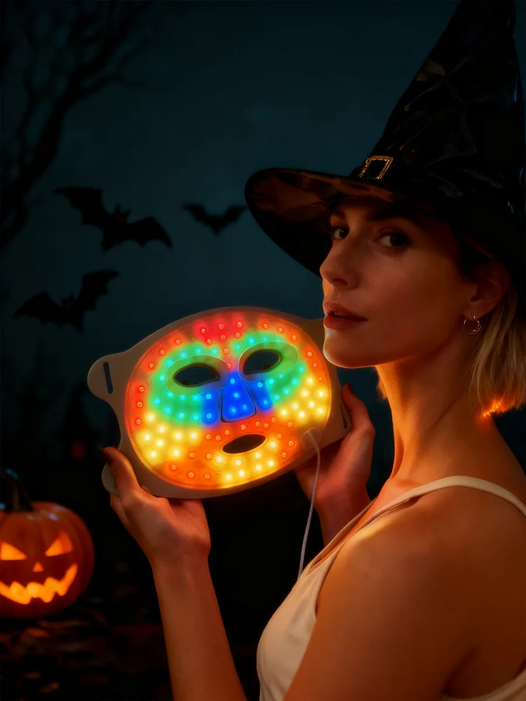 Person wearing a witch hat holding a colorful LED mask with Halloween-themed background