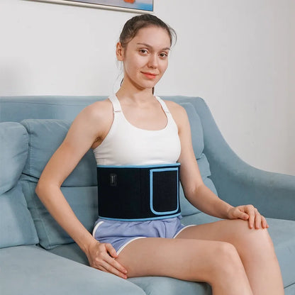 Woman wearing a black waist support belt sitting on a blue couch.